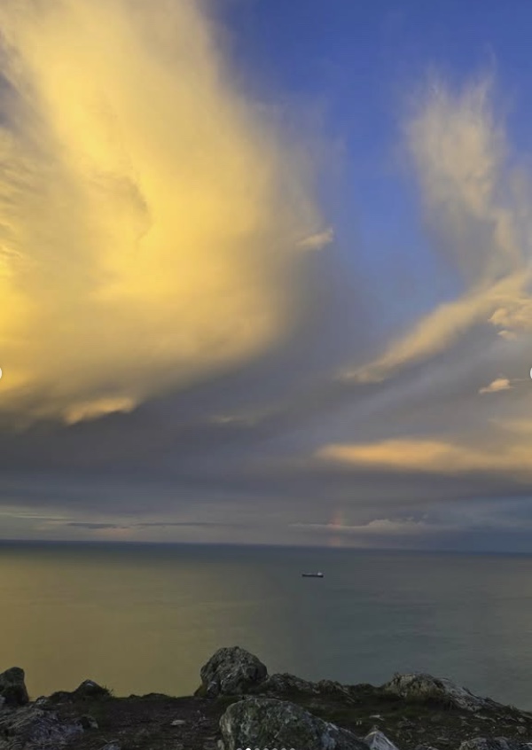 Golden evening clouds over the Irish Sea, a small ship on the horizon